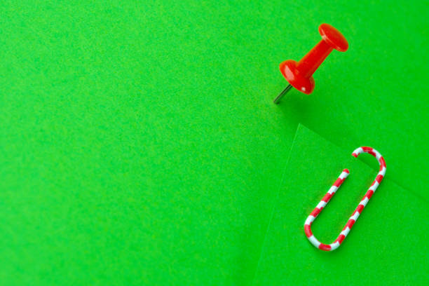 Red paperclip and red button on green blank sheets ストックフォト