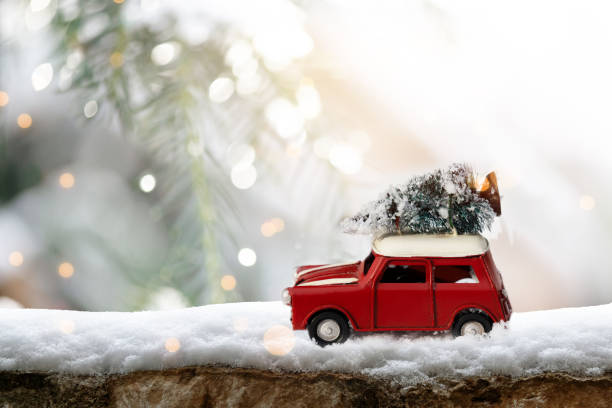 Winter holidays concept with retro car transporting Christmas tree