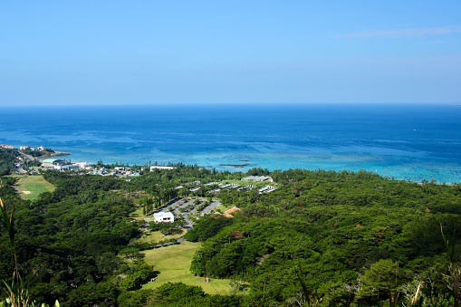 Pristine tropical waters and lush green vegetation of Nago Bay, Okinawa, Japan.