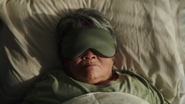 Senior woman sleeping with eye mask.