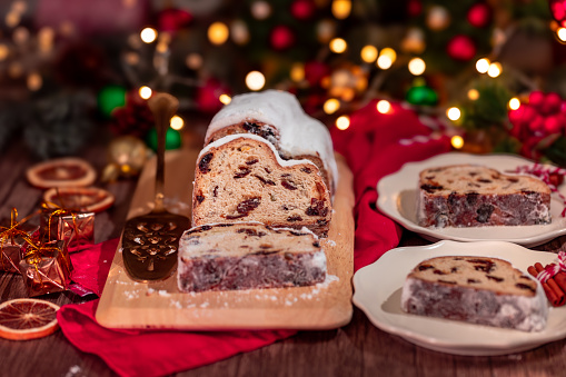 Christmas stollen. Traditional german Christmas dessert and Christmas ornaments on wooden background