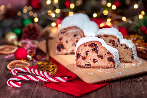 Christmas stollen. Traditional german Christmas dessert and Christmas ornaments on wooden background