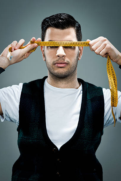 istock Young Man with a Metre Rule in His Face 184712555