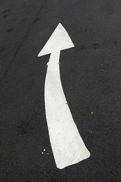 istock Curved White Arrow on a Black Tarmac Road. 184712603