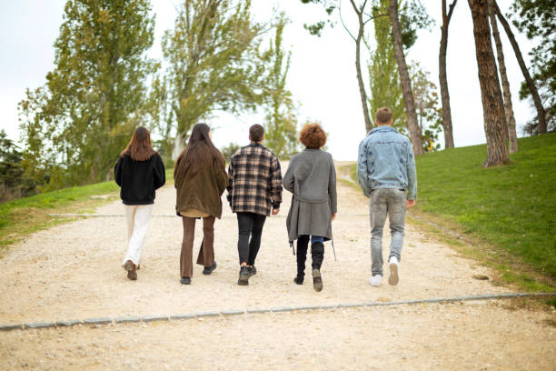 istock Young friends stroll, backs turned, in an autumn park 1847134954