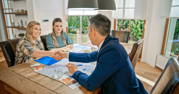 istock Lesbian couple handshaking with financial advisor 1847140017