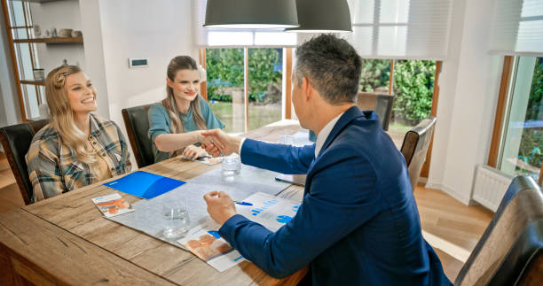istock Lesbian couple handshaking with financial advisor 1847140042