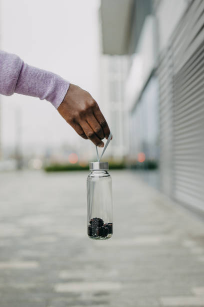 Attractive black woman holding plastic container with water