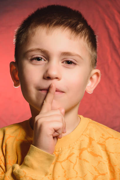 istock The boy with his index finger shows the sign quietly. 1847179206