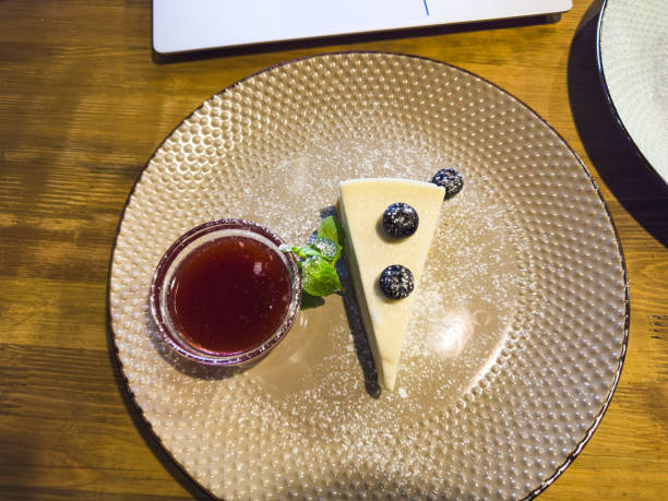 vanilla cheesecake with blueberries, mint leaves, strawberry jam, powdered sugar