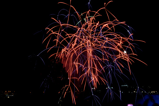 Niagara falls at night with people watching the nightly fireworks with the American falls in the background.