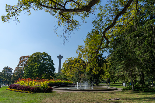 Niagara falls park with a fountain in Autumn.  The Skylon Tower is in the distant background.