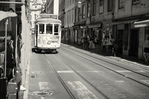 Lisbon, Portugal - July 29, 2023: An old-fashioned tram runs along a street in Lisbon downtown.