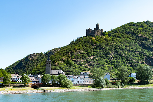 View from the river Rhine at the medieval castle Maus (Mouse) on the top of a hill overlooking the small village of Welmich.