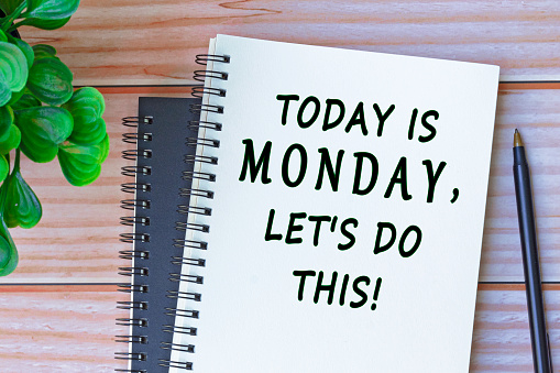 Today is Monday, let's do this written on a notebook with a pen and flower on wooden desk. Motivational concept.