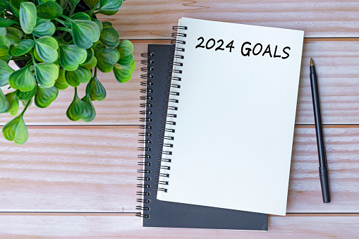 2024 goals written on notebook on office desk table. Business concept. Copy space.