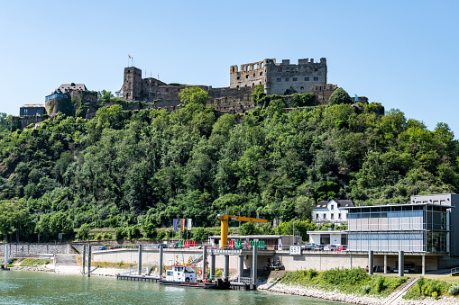 View from the river Rhine at the West bank with the ruins of the Rhieinfels castle near the village of Sankt Goar.
