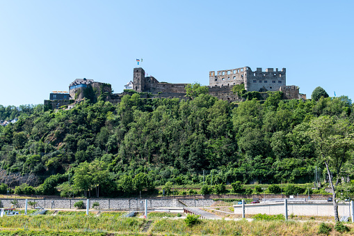 View from the river Rhine at the West bank with the ruins of the Rhieinfels castle near the village of Sankt Goar.