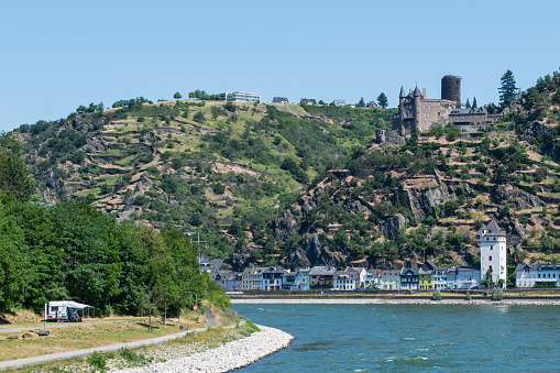 View from the river Rhine at the town of Sankt Goarshausen with the medieval castle Katz (Cat) on the top of a hill overlooking the small village on the East bank of the river Rhine.