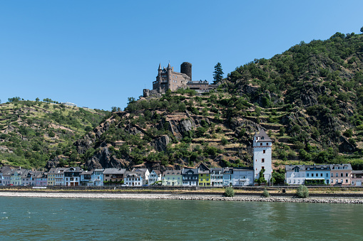 View from the river Rhine at the town of Sankt Goarshausen with the medieval castle Katz (Cat) on the top of a hill overlooking the small village on the East bank of the river Rhine.