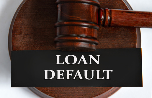 LOAN DEFAULT- words on a black sheet against the background of a judge's gavel. Business concept