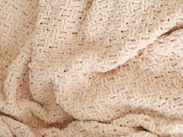 istock Beige knitted plaid close-up. Background. Creases on soft surfaces. 1847259315