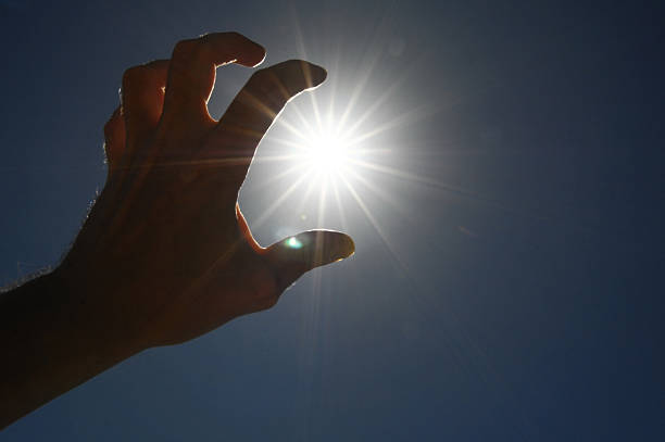 istock One Hand Catching the Sun Stars on a Blue Background 184727792