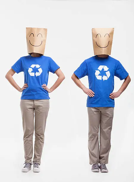 Two young people with smiley face paper bags over their head