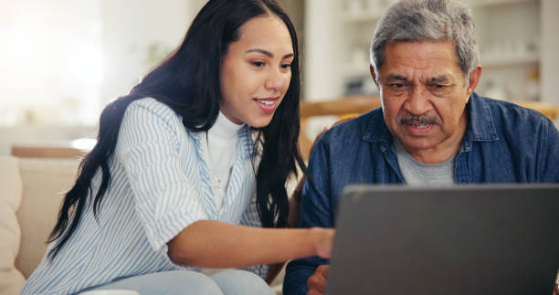 istock Woman, senior father and laptop with teaching, reading and typing for email notification, web or search. Computer, elderly dad and daughter with click, learning and family home lounge on social media 1847335317