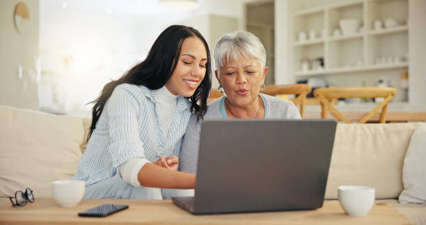 istock Woman, senior mom and laptop with teaching, reading and typing for email notification, web or search. Computer, elderly mother and daughter with click, learning and family home lounge on social media 1847335324