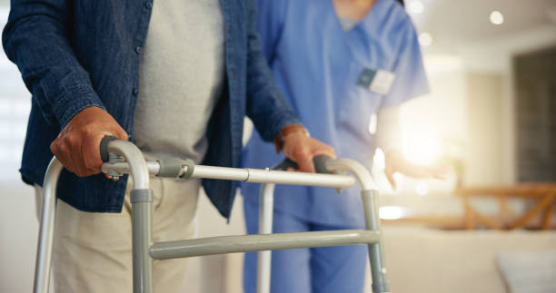 istock Senior man, person with disability and walking frame for support, nurse and handholding. Healthcare, elderly for medical care, patient rehabilitation and physiotherapy for injury and recovery help 1847335325