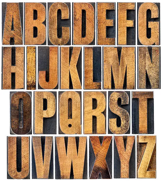 complete English alphabet - a collage of 26 isolated vintage wood letterpress printing blocks, scratched and stained by ink