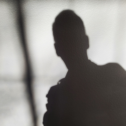 A person passing the photo crew casts a shadow on the wall.