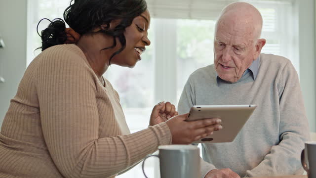 Home, woman and old man with tablet, internet and social media with typing, connection and teaching. Pensioner, senior guy and person with tech, online reading and network with app or caregiver