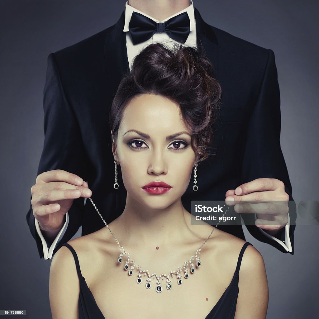 Sensual couple Elegant man on a beautiful woman wears a necklace Jewelry Stock Photo