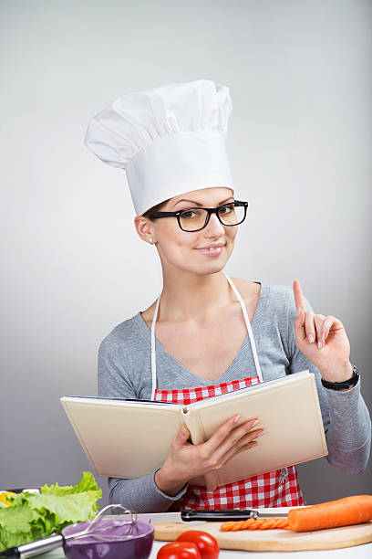 istock Smiling female chef raising the index finger up 184743522