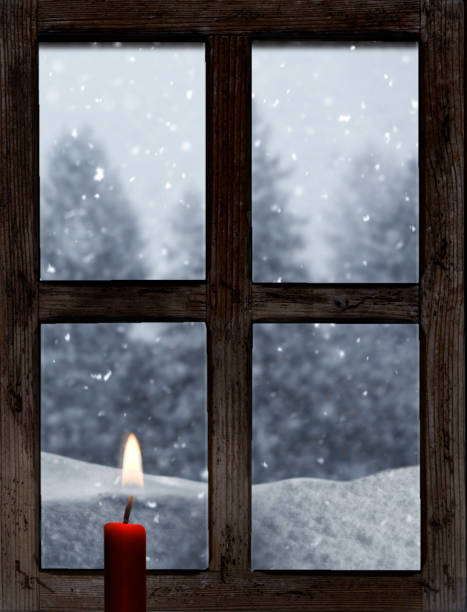 istock View through an old wooden window with a candle in winter 1847439581