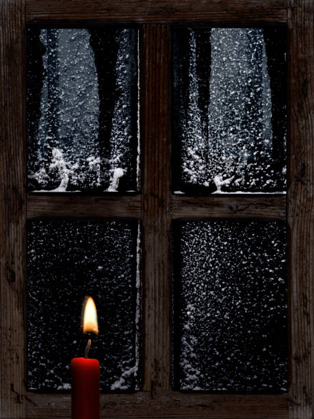 istock View through an old wooden window with a candle in winter 1847439590
