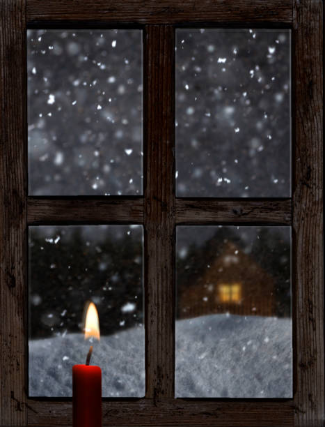 istock View through an old wooden window with a candle in winter 1847439598