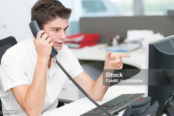 Young Man Is Calling Stock Photo - Download Image Now - Candid, Computer Keyboard, First Job