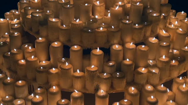 Arrangement of several lit candle lights in a dark room