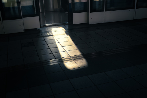 Sunlight shining through the gap in the train doors on the platform.