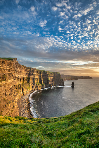 Sunshine illuminates the coastline along the Cliffs of Moher just before sunset in the Burren region in County Clare, Ireland.