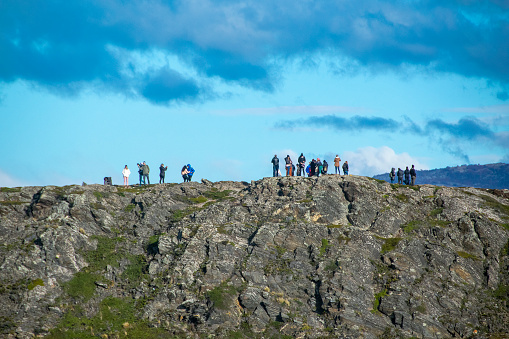 Ushuaia, Argentina; April 15 2022: Group of tourist walking at top of island hill, tierra del fuego, argentina