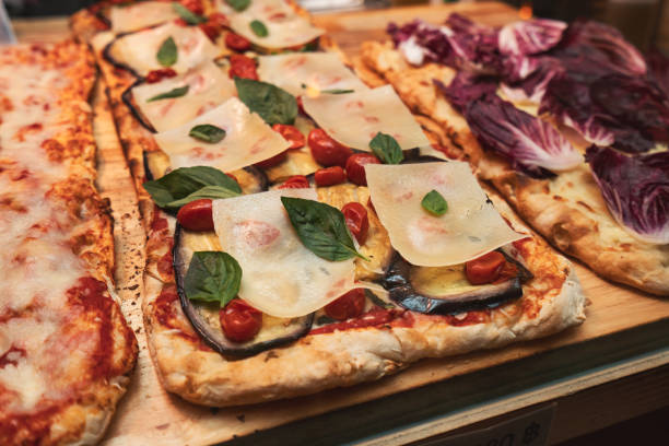 istock Pizza with eggplant, cheese, tomatoes and basil leaves  in shop. 1847501359