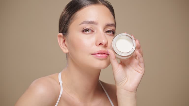 Portrait young woman uses creams of her face