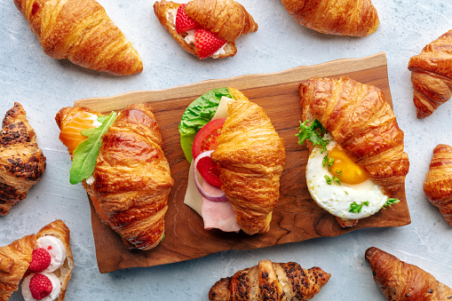 Croissant sandwich variety. Various stuffed croissants, overhead flat lay shot. Many rolls filled with ham, salmon, egg, etc