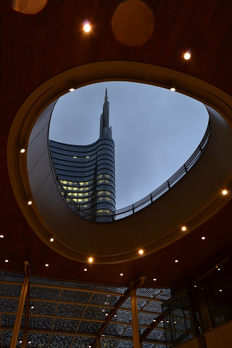 Milan,Italy - April 11, 2013: Sunset view from inside of the Gae Aulenti mall of the futuristic architecture of the Unicredit tower of the Milan Porta Nuova financial and commercial business centre.