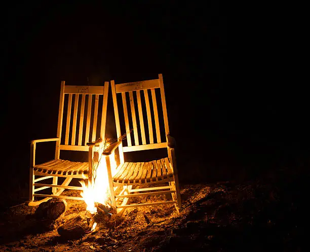 White rocking chairs with flames during the night