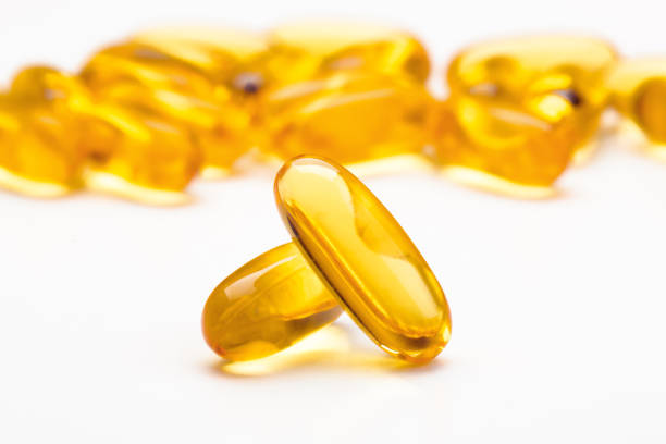 istock Fish oil softgel capsules scattered on a white table, focus on foreground 1847538855